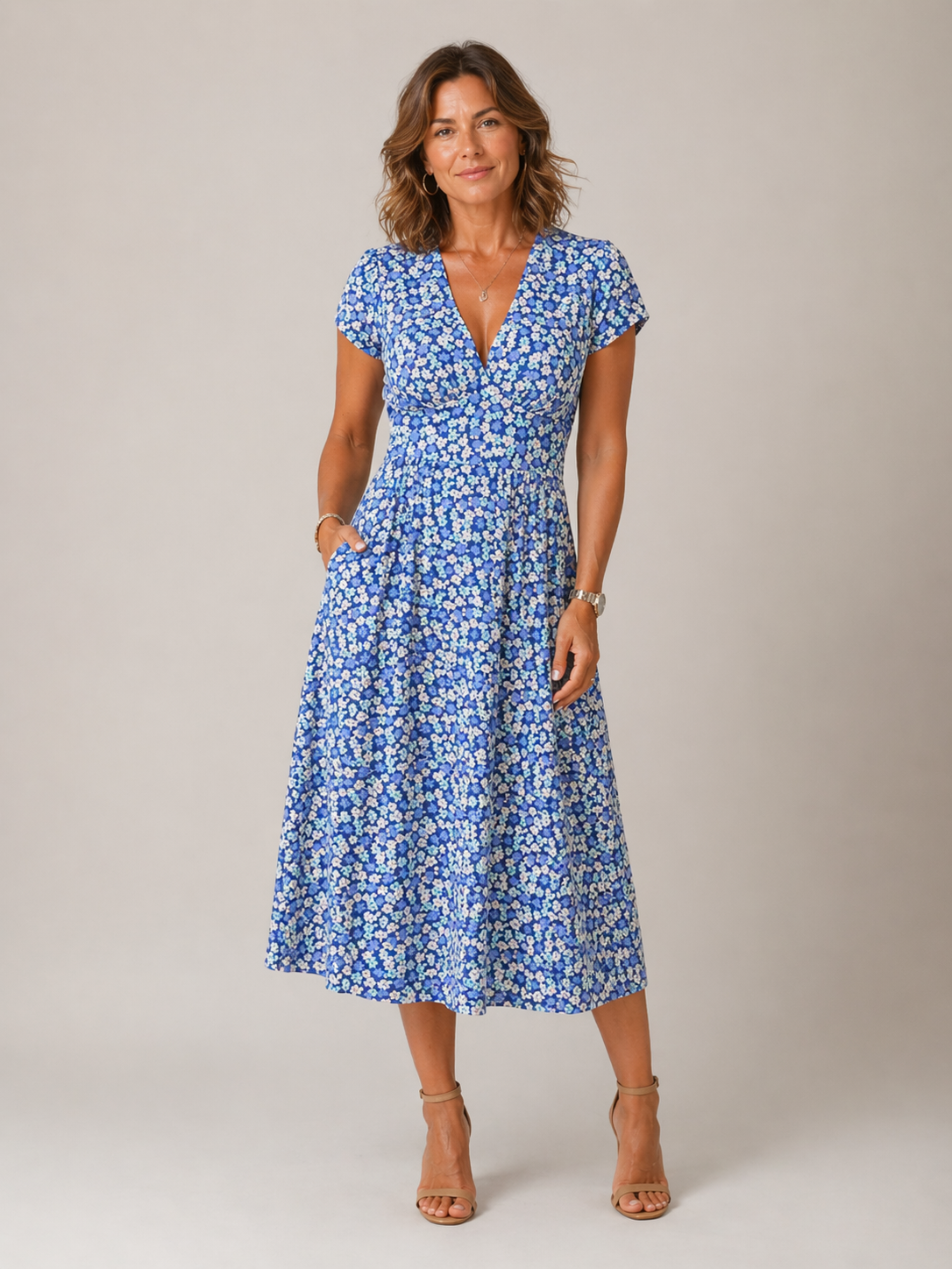 Woman wearing a blue floral dress against a plain background