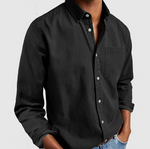 Black button-up shirt worn by a person on a light gray background