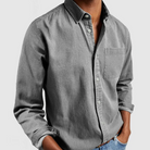 Gray button-up shirt worn by a person on a light gray background