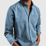 Blue denim shirt worn by a person on a light gray background