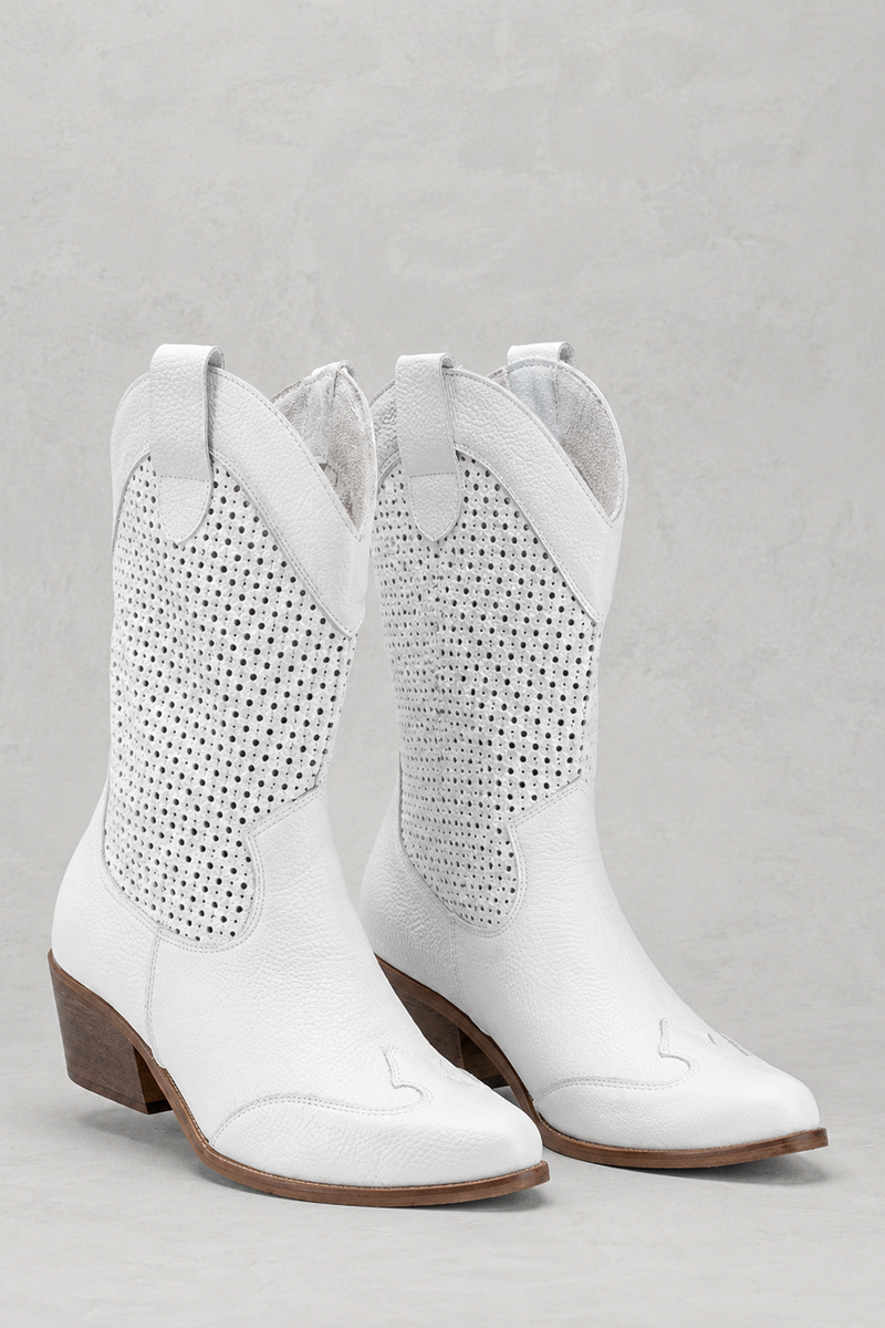 White cowboy boots with studded details on a gray background
