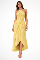 Woman wearing a yellow strapless dress with ruffled layers on a white background