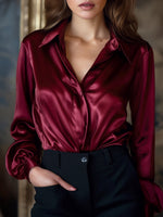 Red satin shirt worn by a person with a blurred background