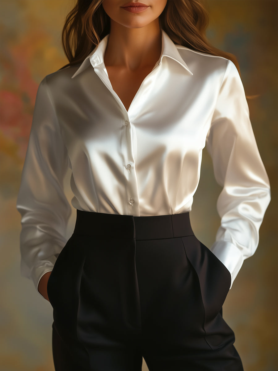 Person wearing a white shirt and black pants against a blurred background