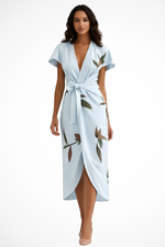 Woman wearing a light blue dress with floral patterns on a white background