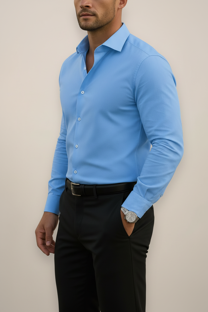 Man wearing a light blue dress shirt and black pants against a beige background