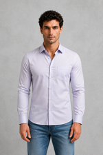 Man wearing a light purple shirt and blue jeans against a gray background