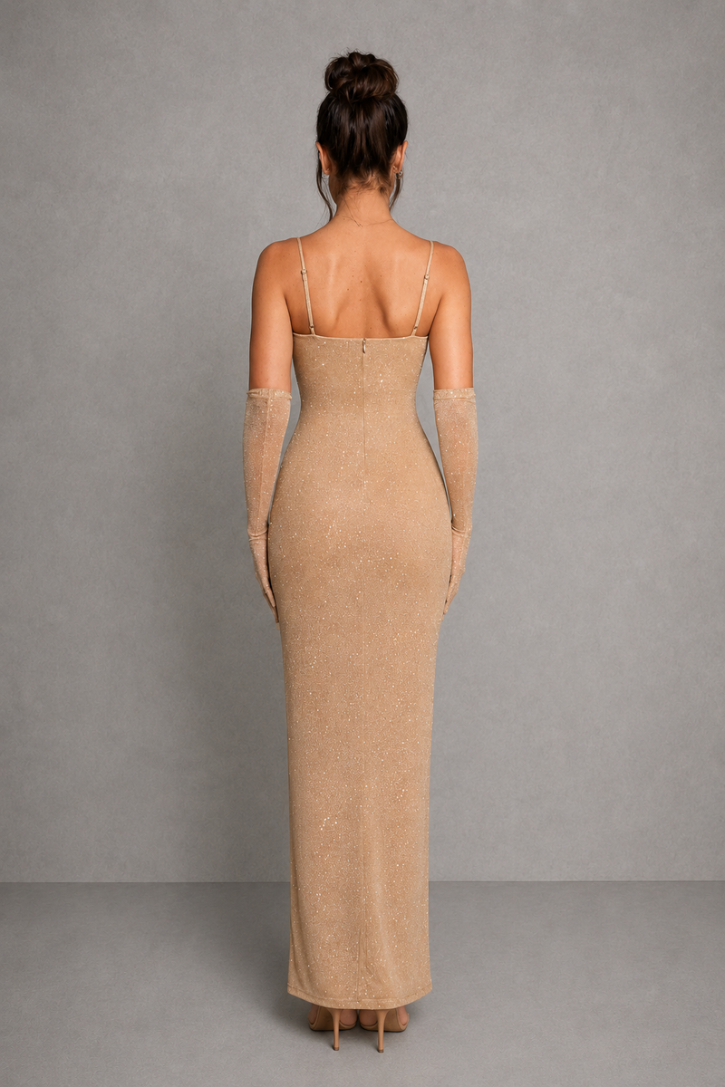 Woman wearing a beige evening gown with sheer sleeves against a gray background