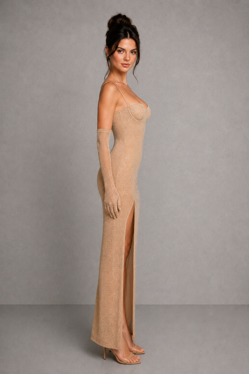 Woman wearing a beige strapless gown with a high slit on a gray background