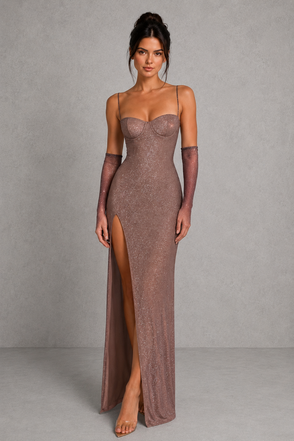 Woman wearing a brown evening gown with a high slit on a gray background