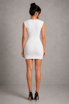 Woman wearing a white dress against a gray background