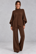 Women’s ribbed knit two-piece set with an asymmetric high-neck jumper, draped crossover hem and matching wide leg trousers.