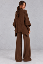 Women’s ribbed knit two-piece set with an asymmetric high-neck jumper, draped crossover hem and matching wide leg trousers.