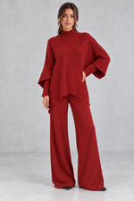Women’s ribbed knit two-piece set with an asymmetric high-neck jumper, draped crossover hem and matching wide leg trousers.
