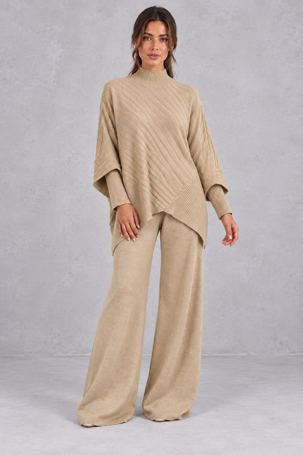 Women’s ribbed knit two-piece set with an asymmetric high-neck jumper, draped crossover hem and matching wide leg trousers.