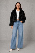 Women’s black faux fur coat with a soft plush texture, refined tailored silhouette and elegant finish for autumn and winter styling.