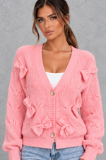 Women’s knitted cardigan with decorative fabric bows, a V-neckline, button front, textured knit finish and slightly cropped silhouette.