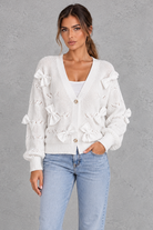 Women’s knitted cardigan with decorative fabric bows, a V-neckline, button front, textured knit finish and slightly cropped silhouette.