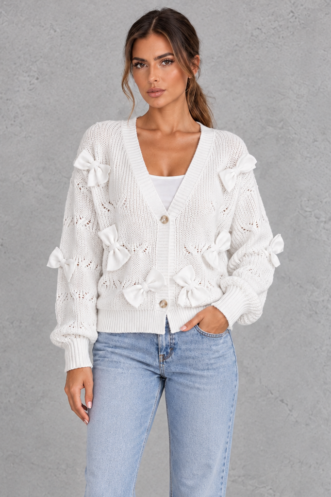Women’s knitted cardigan with decorative fabric bows, a V-neckline, button front, textured knit finish and slightly cropped silhouette.