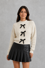 Women’s cable knit cardigan with feminine bow tie front, long sleeves and textured knitted design for autumn and winter layering.