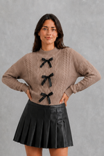 Women’s cable knit cardigan with feminine bow tie front, long sleeves and textured knitted design for autumn and winter layering.