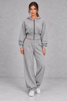 Shop this women’s cinched waist hoodie and wide leg jogger set with a relaxed fit and grey marl finish. Perfect for travel, lounging and casual everyday wear.