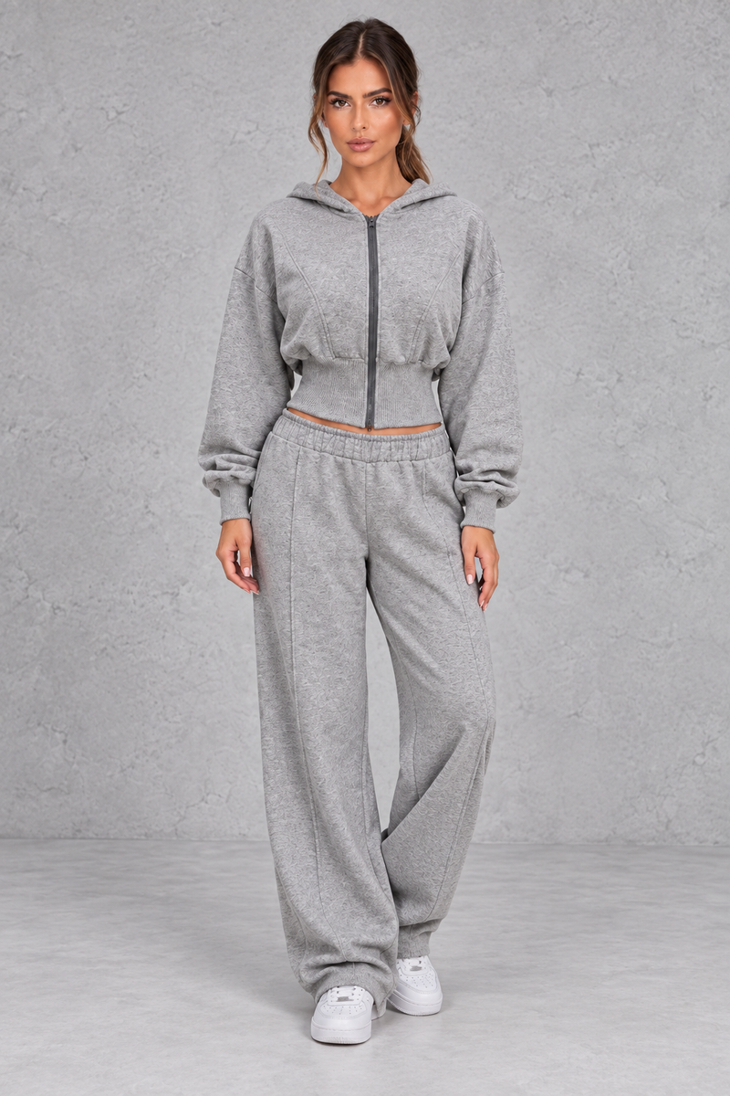 Shop this women’s cinched waist hoodie and wide leg jogger set with a relaxed fit and grey marl finish. Perfect for travel, lounging and casual everyday wear.