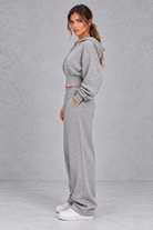 Shop this women’s cinched waist hoodie and wide leg jogger set with a relaxed fit and grey marl finish. Perfect for travel, lounging and casual everyday wear.