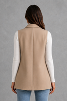 Women’s coffee brown sleeveless longline blazer with notch lapels, double-breasted button fastening, defined waist and flap pockets.