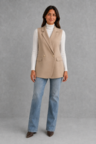 Women’s coffee brown sleeveless longline blazer with notch lapels, double-breasted button fastening, defined waist and flap pockets.