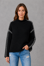 Women’s oversized black crew neck knit jumper with white contrast stitch detailing across the shoulders and long sleeves.