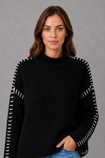 Women’s oversized black crew neck knit jumper with white contrast stitch detailing across the shoulders and long sleeves.