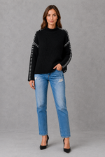 Women’s oversized black crew neck knit jumper with white contrast stitch detailing across the shoulders and long sleeves.