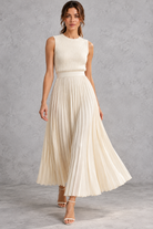 Women's cream pleated skirt co-ord set with sleeveless ribbed knit top and maxi skirt – front view