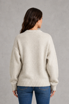 Light grey women’s crew neck knit jumper with an oversized relaxed fit, dropped shoulders and loose wide long sleeves.