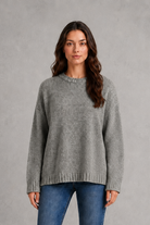 Light grey women’s crew neck knit jumper with an oversized relaxed fit, dropped shoulders and loose wide long sleeves.