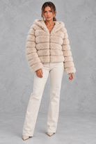 Women’s cropped faux fur winter jacket with a plush hood, horizontal panelled detailing, long sleeves and a voluminous silhouette.