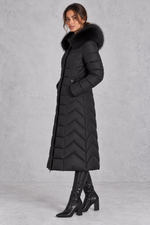 Women’s longline puffer coat with a plush faux fur-trimmed hood, chevron quilting, padded sleeves and a gently defined waist.