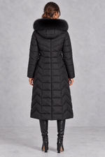 Women’s longline puffer coat with a plush faux fur-trimmed hood, chevron quilting, padded sleeves and a gently defined waist.