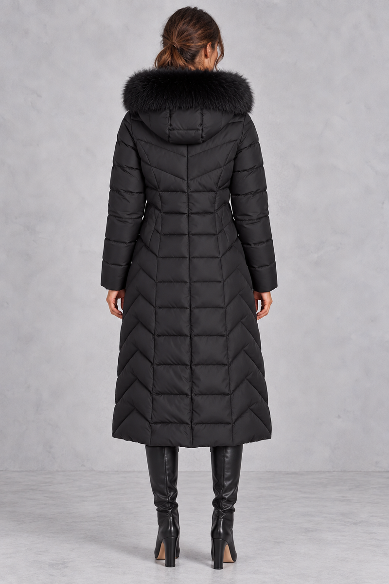 Women’s longline puffer coat with a plush faux fur-trimmed hood, chevron quilting, padded sleeves and a gently defined waist.
