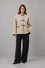 Women’s oversized faux fur toggle jacket with contrast trim, front pockets and a warm textured finish