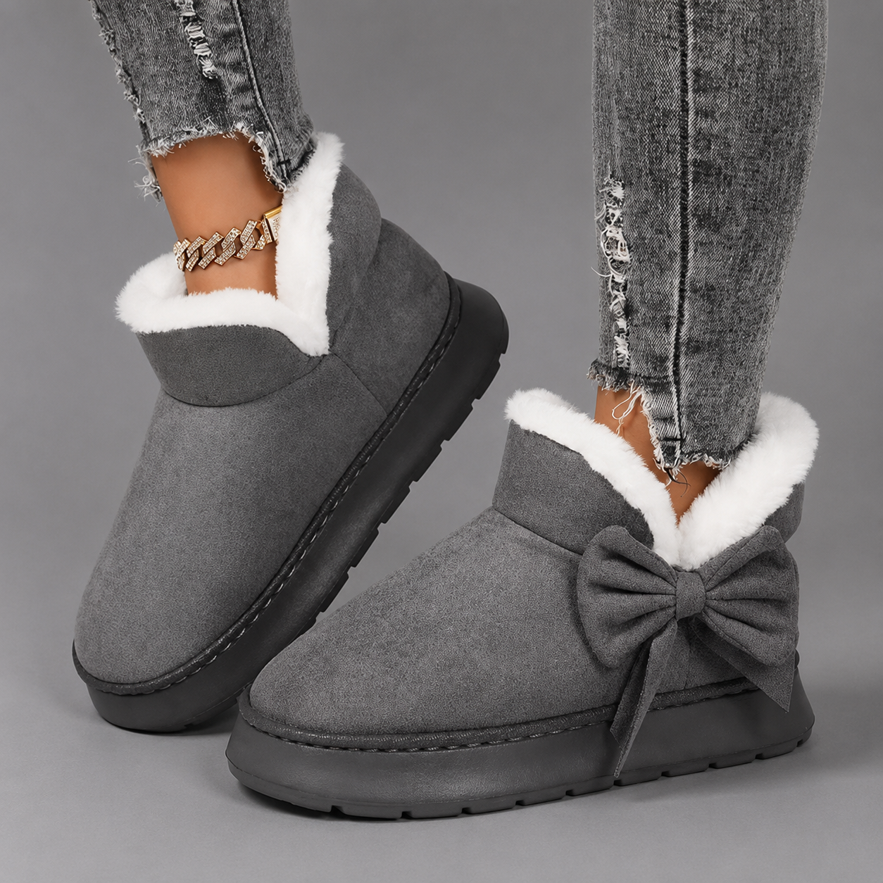 Women's faux suede winter boot slippers with plush fleece lining, side bow detail, cushioned platform sole and non-slip outsole, designed for warm, comfortable indoor wear and light outdoor use during autumn and winter.