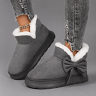 Women's faux suede winter boot slippers with plush fleece lining, side bow detail, cushioned platform sole and non-slip outsole, designed for warm, comfortable indoor wear and light outdoor use during autumn and winter.