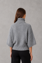 Women’s high neck batwing knit jumper with textured waist-cinching design for autumn and winter.
