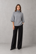 Women’s high neck batwing knit jumper with textured waist-cinching design for autumn and winter.