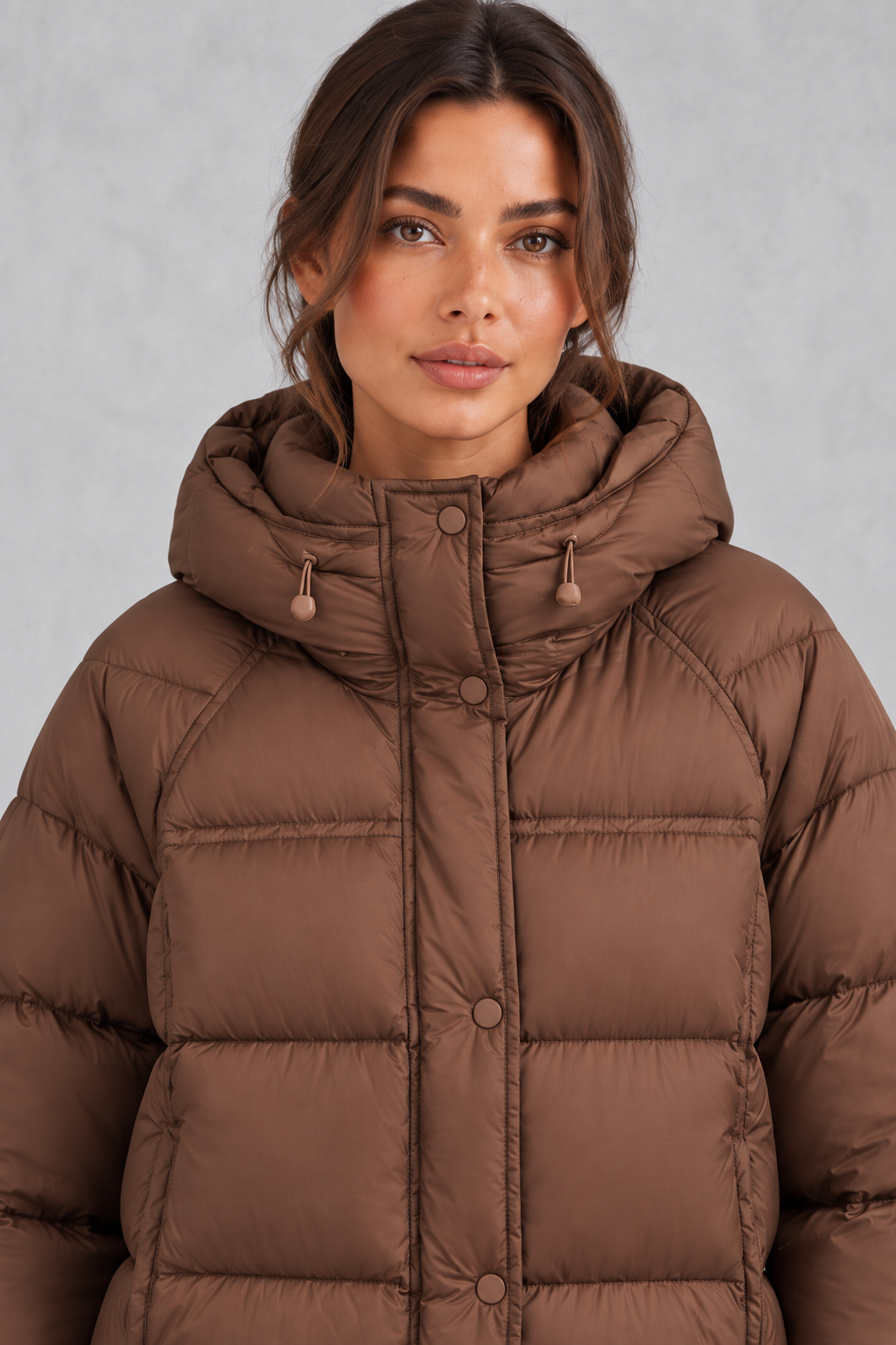 Women’s hooded puffer jacket with generous padding, a large hood, high protective neckline, long sleeves and relaxed silhouette.