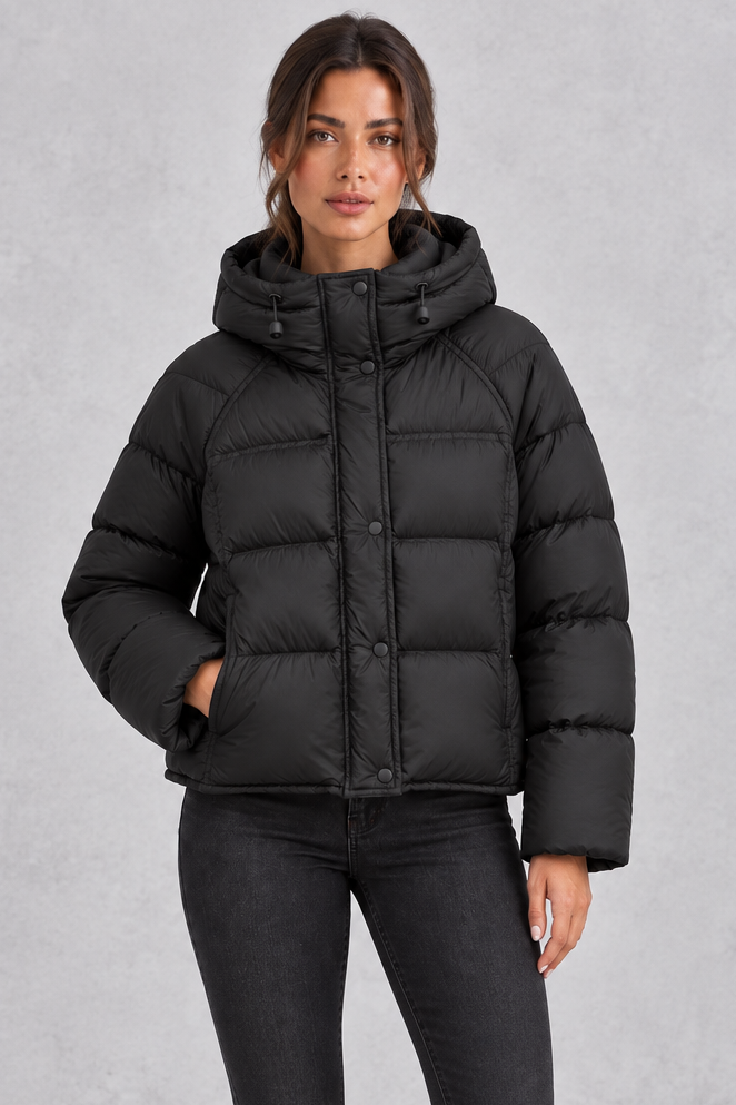 Women’s hooded puffer jacket with generous padding, a large hood, high protective neckline, long sleeves and relaxed silhouette.
