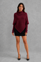 Women’s high neck knit jumper with oversized batwing sleeves, rib-knit texture and an asymmetric split hem.