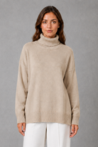 Women’s high neck knit jumper with a relaxed loose fit, cosy turtleneck, long sleeves and soft knitted finish for autumn and winter.