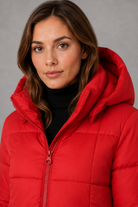 Women’s hooded puffer coat with lightweight insulated padding, structured hood and a flattering feminine silhouette for cold-weather wear.